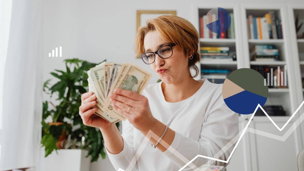 Como ganhar renda extra em 2026 - Uma mulher loira de óculos, vestindo uma blusa branca, segura várias notas de dólar em formato de leque enquanto faz uma expressão de dúvida ou planejamento. Sobreposta à imagem, há gráficos financeiros estilizados em azul e cinza, incluindo um gráfico de pizza e um de linhas brancas que sobe e desce. O fundo mostra uma estante de livros e uma planta.